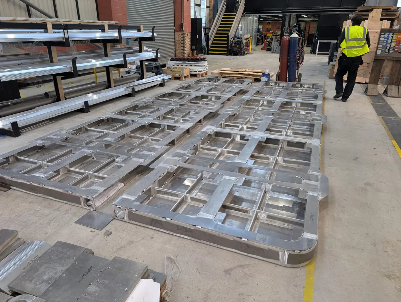 Two aluminium moonpool door leaves during fabrication, showing the internal stiffener framework